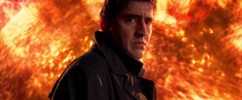 Movie still from “Spider-Man 2” (2004), directed by Sam Raimi – A person wearing a jacket in front of fire; Close Up shot, Over the shoulder angle