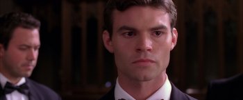 Movie still from “Spider-Man 2” (2004), directed by Sam Raimi – A person wearing a suit and bow tie; Close Up shot, Low angle