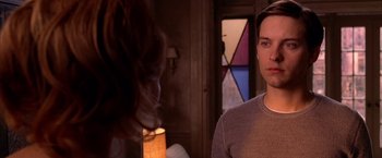 Movie still from “Spider-Man 2” (2004), directed by Sam Raimi – A man standing in front of a lamp in a living room; Close Up shot, Over the shoulder angle