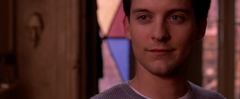 Movie still from “Spider-Man 2” (2004), directed by Sam Raimi – A young man's face in front of a stained glass window; Close Up shot, Over the shoulder angle