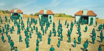 Movie still from “Squid Game” (2021), created by Hwang Dong-hyuk – A group of people standing in the dirt; Extreme Wide shot, High angle