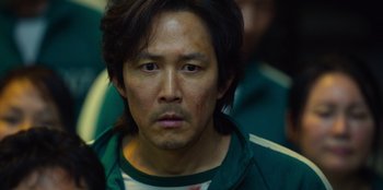 Movie still from “Squid Game” (2021), created by Hwang Dong-hyuk – A person wearing a green shirt; Close Up shot, Low angle