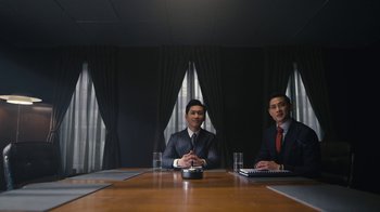 Movie still from “Mr. Robot” (2015), created by Sam Esmail – Two men in suits sitting at a conference room table; Medium shot, Low angle