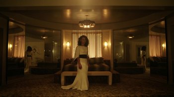 Movie still from “Mr. Robot” (2015), created by Sam Esmail – A woman in a white dress standing in front of a couch; Wide shot, Low angle