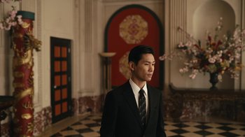 Movie still from “Mr. Robot” (2015), created by Sam Esmail – A man in a suit and tie standing in front of a wall; Medium shot, Low angle