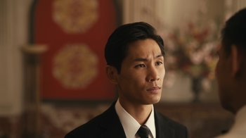 Movie still from “Mr. Robot” (2015), created by Sam Esmail – A man wearing a suit and tie in front of a painting; Close Up shot, Low angle