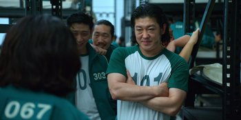Movie still from “Squid Game” (2021), created by Hwang Dong-hyuk – A group of men standing next to each other; Close Up shot, Over the shoulder angle