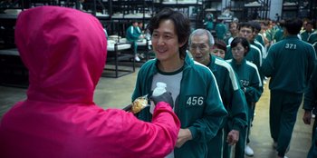 Movie still from “Squid Game” (2021), created by Hwang Dong-hyuk – A group of people standing in a room; Medium shot, Over the shoulder angle