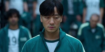 Movie still from “Squid Game” (2021), created by Hwang Dong-hyuk – A man in a green jacket is looking down; Close Up shot, Low angle