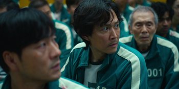 Movie still from “Squid Game” (2021), created by Hwang Dong-hyuk – A group of people sitting in a room; Close Up shot, Over the shoulder angle