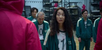 Movie still from “Squid Game” (2021), created by Hwang Dong-hyuk – A group of people walking down a street; Medium shot, Over the shoulder angle