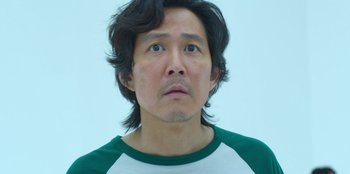 Movie still from “Squid Game” (2021), created by Hwang Dong-hyuk – A person with long black hair; Close Up shot, Low angle