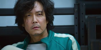 Movie still from “Squid Game” (2021), created by Hwang Dong-hyuk – A person with long hair; Close Up shot, Low angle