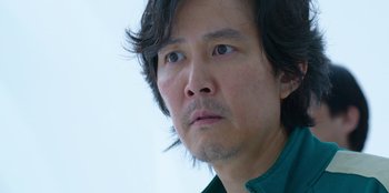 Movie still from “Squid Game” (2021), created by Hwang Dong-hyuk – A person wearing a green shirt; Close Up shot, Low angle