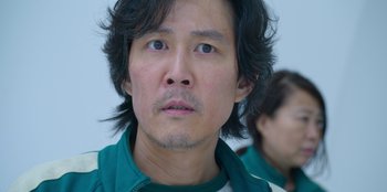 Movie still from “Squid Game” (2021), created by Hwang Dong-hyuk – A person wearing a green jacket; Close Up shot, Low angle