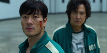 Movie still from “Squid Game” (2021), created by Hwang Dong-hyuk – Two asian men with blood on their face and neck; Close Up shot, Over the shoulder angle