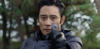 Movie still from “Squid Game” (2021), created by Hwang Dong-hyuk – A person holding a gun; Close Up shot, Over the shoulder angle
