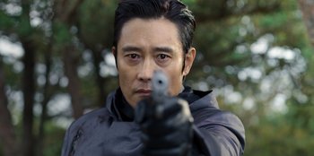 Movie still from “Squid Game” (2021), created by Hwang Dong-hyuk – A person holding a gun; Close Up shot, Over the shoulder angle