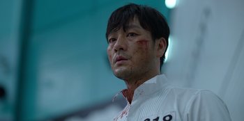 Movie still from “Squid Game” (2021), created by Hwang Dong-hyuk – A person with blood all over his face; Close Up shot, Low angle