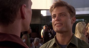 Movie still from “Starship Troopers” (1997), directed by Paul Verhoeven – A man in a green shirt talking to another man in a green shirt; Close Up shot, Over the shoulder angle