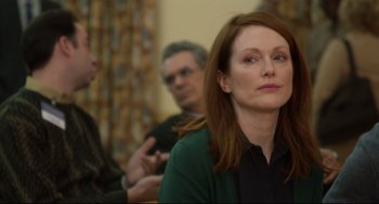 Movie still from “Still Alice” (2014), directed by Richard Glatzer – Julianne moore at a press conference for still alice; Close Up shot, Over the shoulder angle