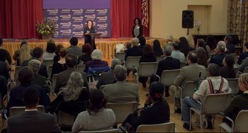 Movie still from “Still Alice” (2014), directed by Richard Glatzer – A woman is giving a presentation to a crowd of onlookers; Wide shot, High angle