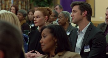 Movie still from “Still Alice” (2014), directed by Richard Glatzer – A group of people sitting in front of a crowd of onlookers; Close Up shot, Over the shoulder angle