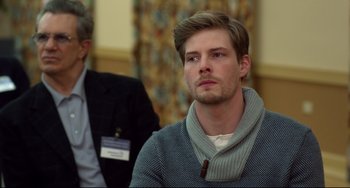 Movie still from “Still Alice” (2014), directed by Richard Glatzer – A young man in a gray sweater looks to his left; Close Up shot, Over the shoulder angle