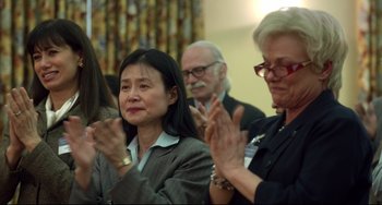 Movie still from “Still Alice” (2014), directed by Richard Glatzer – A group of people clapping in a room; Medium shot, Over the shoulder angle