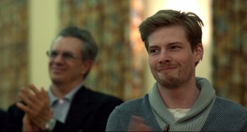 Movie still from “Still Alice” (2014), directed by Richard Glatzer – A man with a goatee is smiling for the camera; Close Up shot, Over the shoulder angle