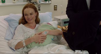 Movie still from “Still Alice” (2014), directed by Richard Glatzer – A woman in a hospital bed holding a baby; Medium shot, Over the shoulder angle