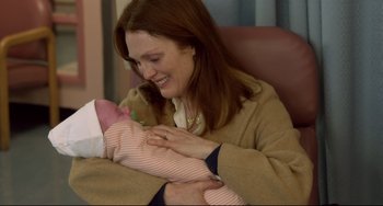 Movie still from “Still Alice” (2014), directed by Richard Glatzer – A woman holding a baby in her arms and smiling; Close Up shot, Over the shoulder angle