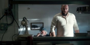 Movie still from “Stranger Things” (2016), created by Ross Duffer – A man standing in front of a mirror next to another man; Medium shot, Over the shoulder angle