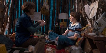 Movie still from “Stranger Things” (2016), created by Ross Duffer – A group of young people sitting on the ground; Medium shot, Over the shoulder angle