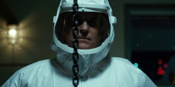 Movie still from “Stranger Things” (2016), created by Ross Duffer – A man in a white suit and a chain around his neck; Close Up shot, Low angle