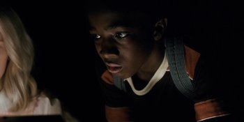 Movie still from “Stranger Things” (2016), created by Ross Duffer – A young man looking up into a dark room; Close Up shot, High angle