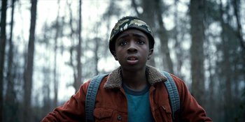 Movie still from “Stranger Things” (2016), created by Ross Duffer – A young man wearing a hat and a jacket; Close Up shot, Low angle