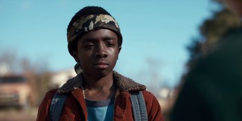 Movie still from “Stranger Things” (2016), created by Ross Duffer – A young man wearing a bandana and a brown jacket; Close Up shot, Low angle