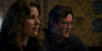 Movie still from “Stranger Things” (2016), created by Ross Duffer – A man and a woman sitting next to each other in a room; Close Up shot, Over the shoulder angle