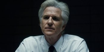 Movie still from “Stranger Things” (2016), created by Ross Duffer – An older man wearing a white shirt and a tie; Close Up shot, Over the shoulder angle