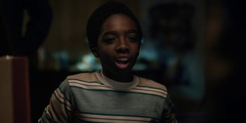 Movie still from “Stranger Things” (2016), created by Ross Duffer – A young boy is smiling for the camera; Close Up shot, Low angle