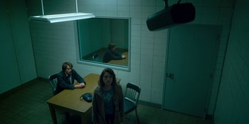 Movie still from “Stranger Things” (2016), created by Ross Duffer – Two people sitting at a table in front of a mirror; Wide shot, Over the shoulder angle
