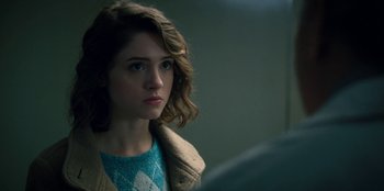 Movie still from “Stranger Things” (2016), created by Ross Duffer – A young woman is looking at the camera; Close Up shot, Over the shoulder angle
