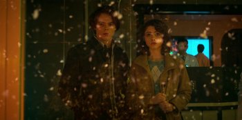 Movie still from “Stranger Things” (2016), created by Ross Duffer – A man and a woman standing next to each other; Medium shot, Low angle