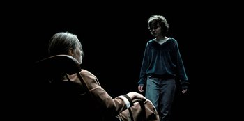 Movie still from “Stranger Things” (2016), created by Ross Duffer – A woman sitting in a chair next to a man; Medium shot, Over the shoulder angle