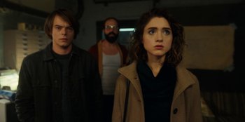 Movie still from “Stranger Things” (2016), created by Ross Duffer – A group of people standing next to each other in a room; Medium shot, Over the shoulder angle