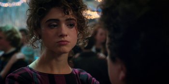 Movie still from “Stranger Things” (2016), created by Ross Duffer – A young woman with curly hair is looking at a man; Close Up shot, Over the shoulder angle