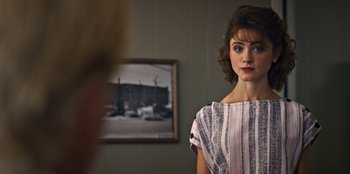 Movie still from “Stranger Things” (2016), created by Ross Duffer – A woman standing in front of a mirror in a room; Close Up shot, Over the shoulder angle