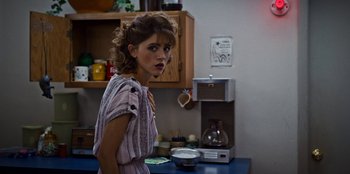 Movie still from “Stranger Things” (2016), created by Ross Duffer – A woman standing in front of a coffee maker; Medium shot, Over the shoulder angle