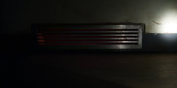 Movie still from “Stranger Things” (2016), created by Ross Duffer – A dark room with a red stripe on the wall; Extreme Close Up shot, Low angle